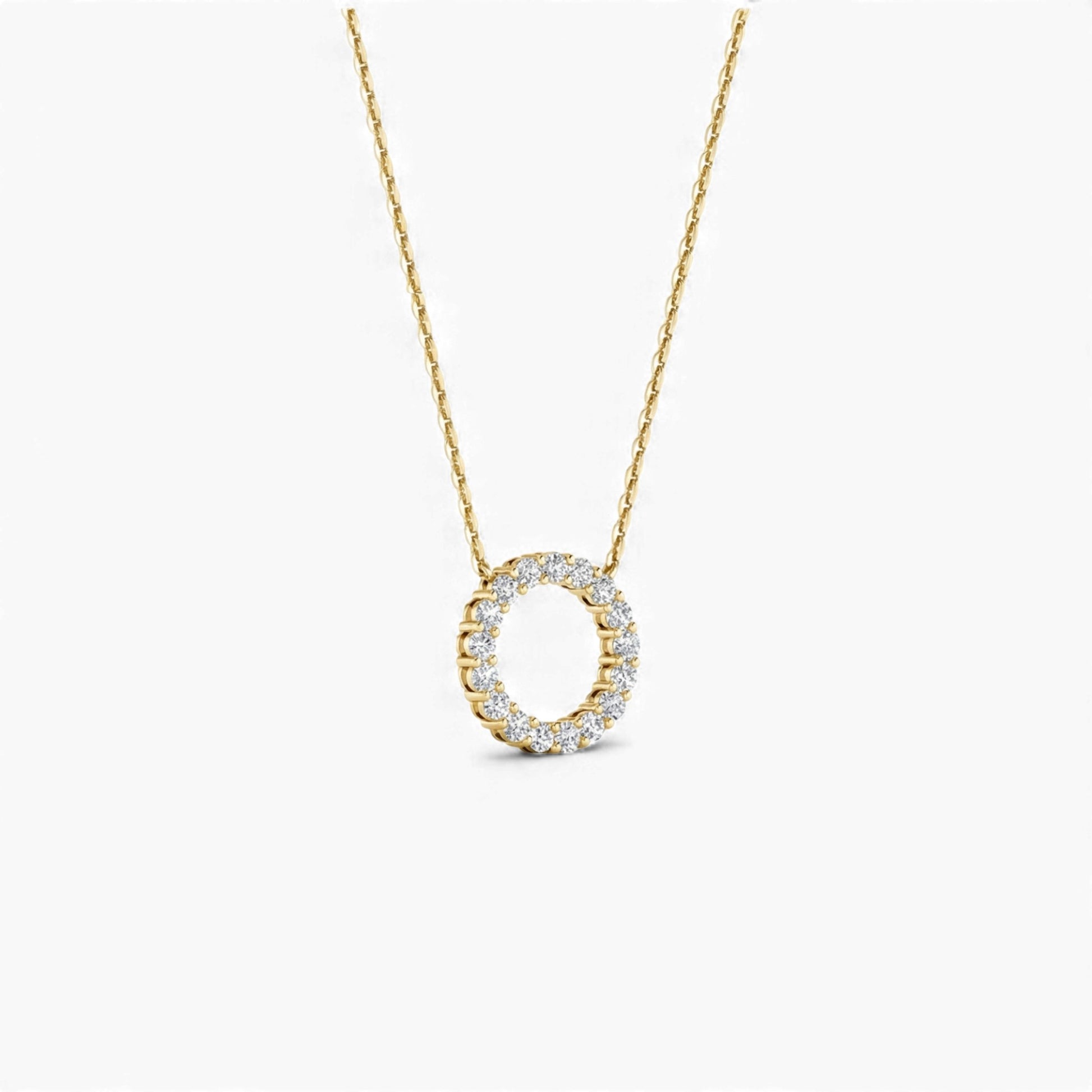 Gold necklace with a circular pendant on a white background