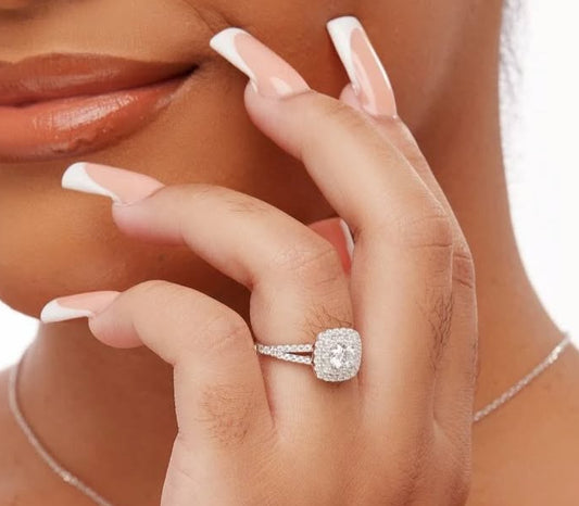 A woman's hand with a cushion cut moissanite engagement ring on her finger.