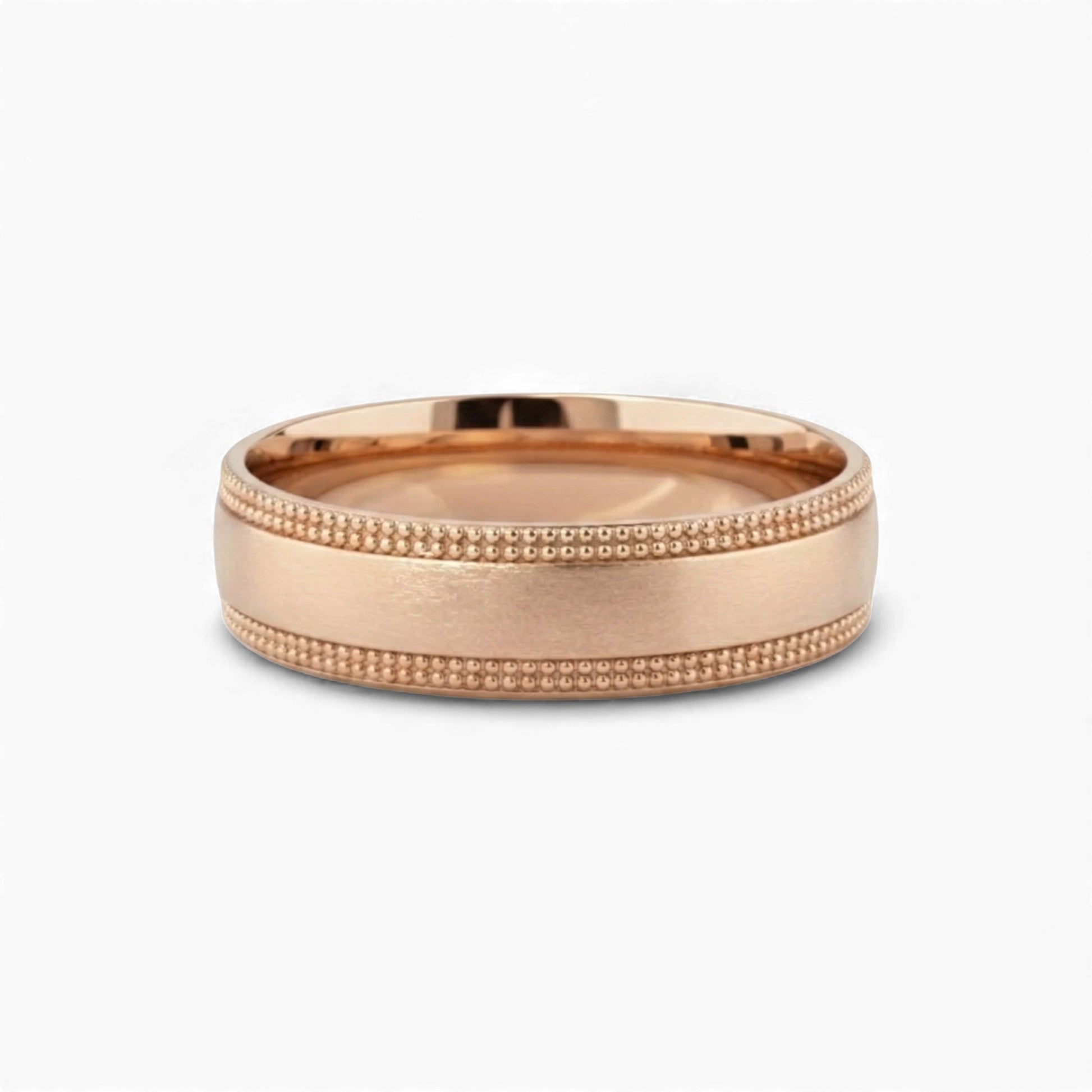 Rose gold ring with milgrain detailing on a white background