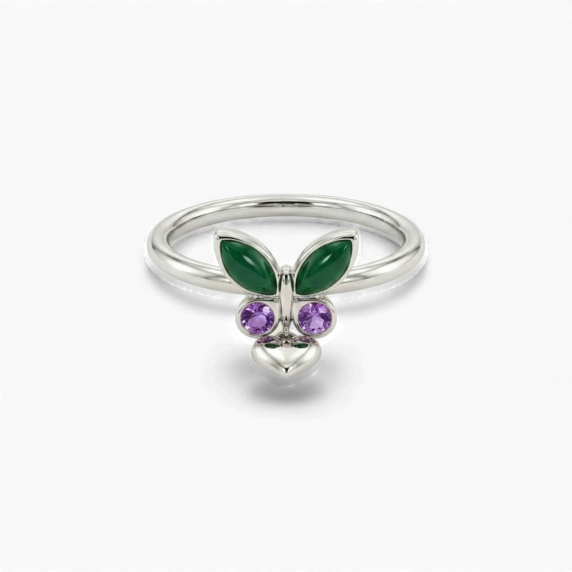 Silver ring with green butterfly wings and purple gemstones on a white background