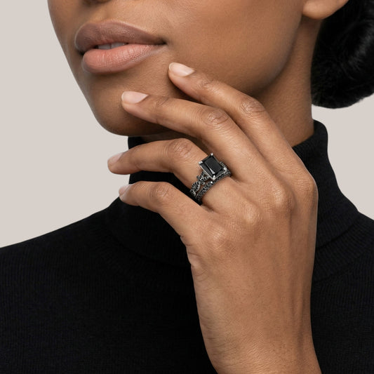 Close-up of a hand wearing a ring with a black background