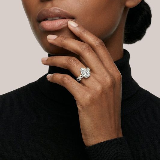 Woman wearing a diamond ring on her hand against a neutral background
