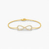 Gold infinity bracelet on a white background