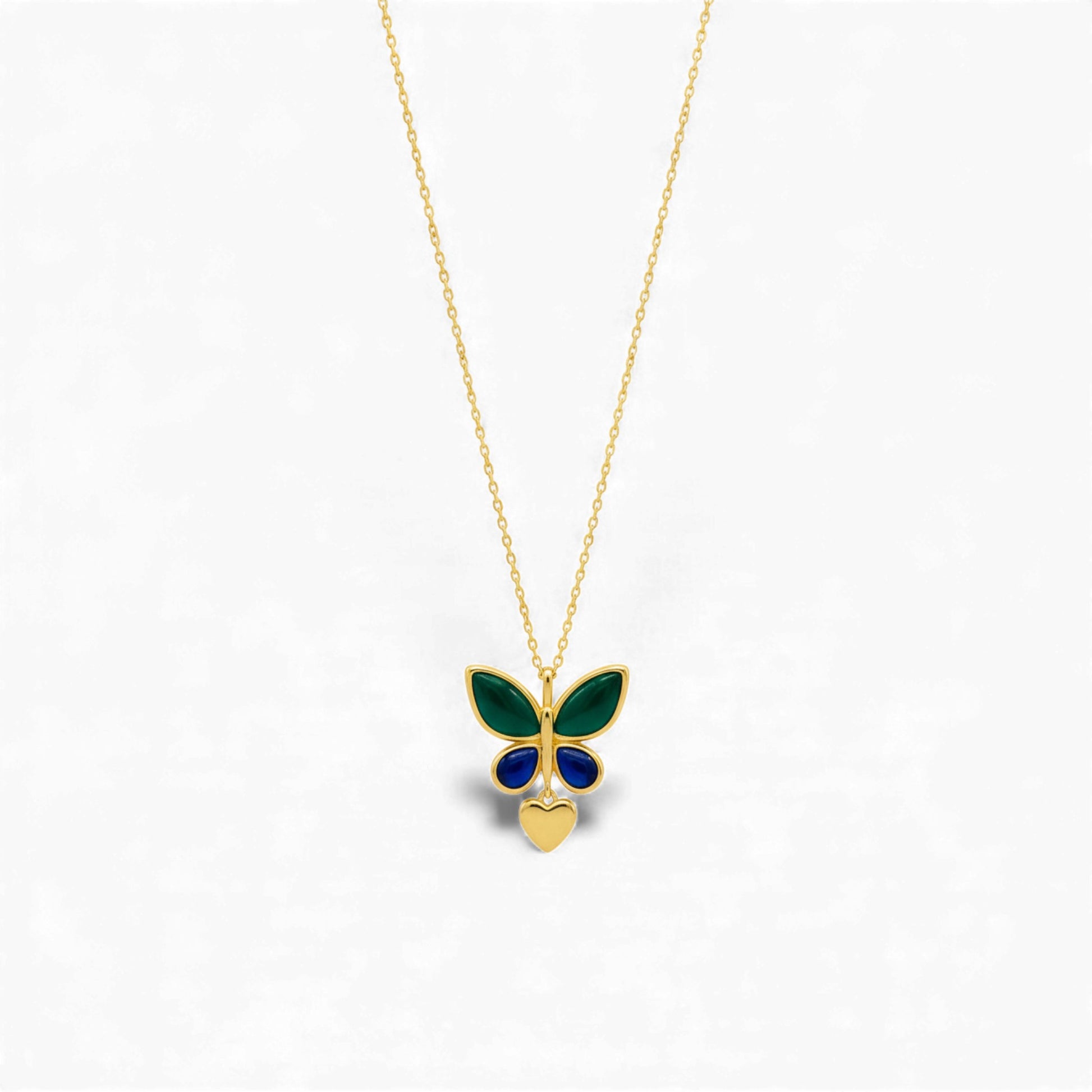 Butterfly-shaped pendant on a gold chain against a white background