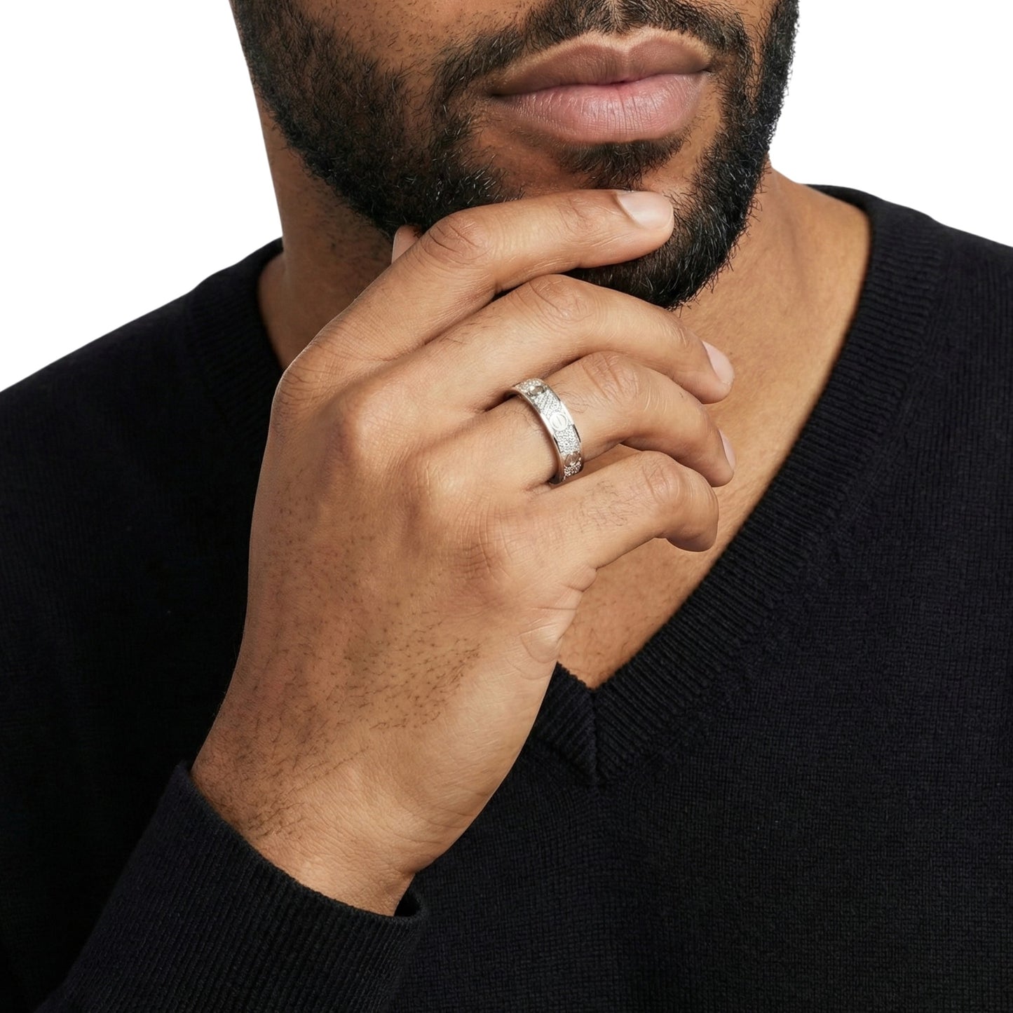 Man wearing a black sweater with a close-up of his hand and ring.