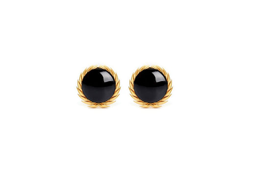 A pair of 18karat gold stud earrings with black onyx centers, surrounded by gold filigree designs.