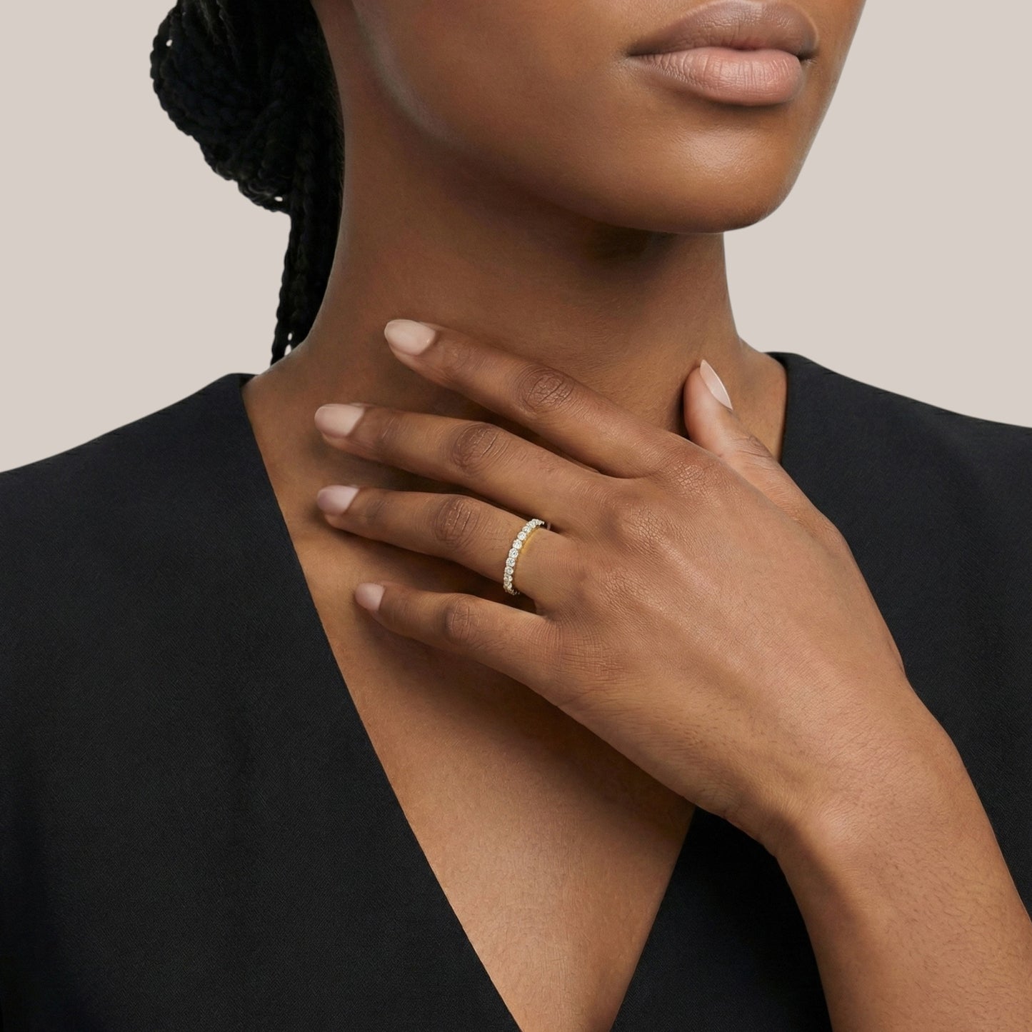 Woman wearing a gold ring on her hand with a neutral background