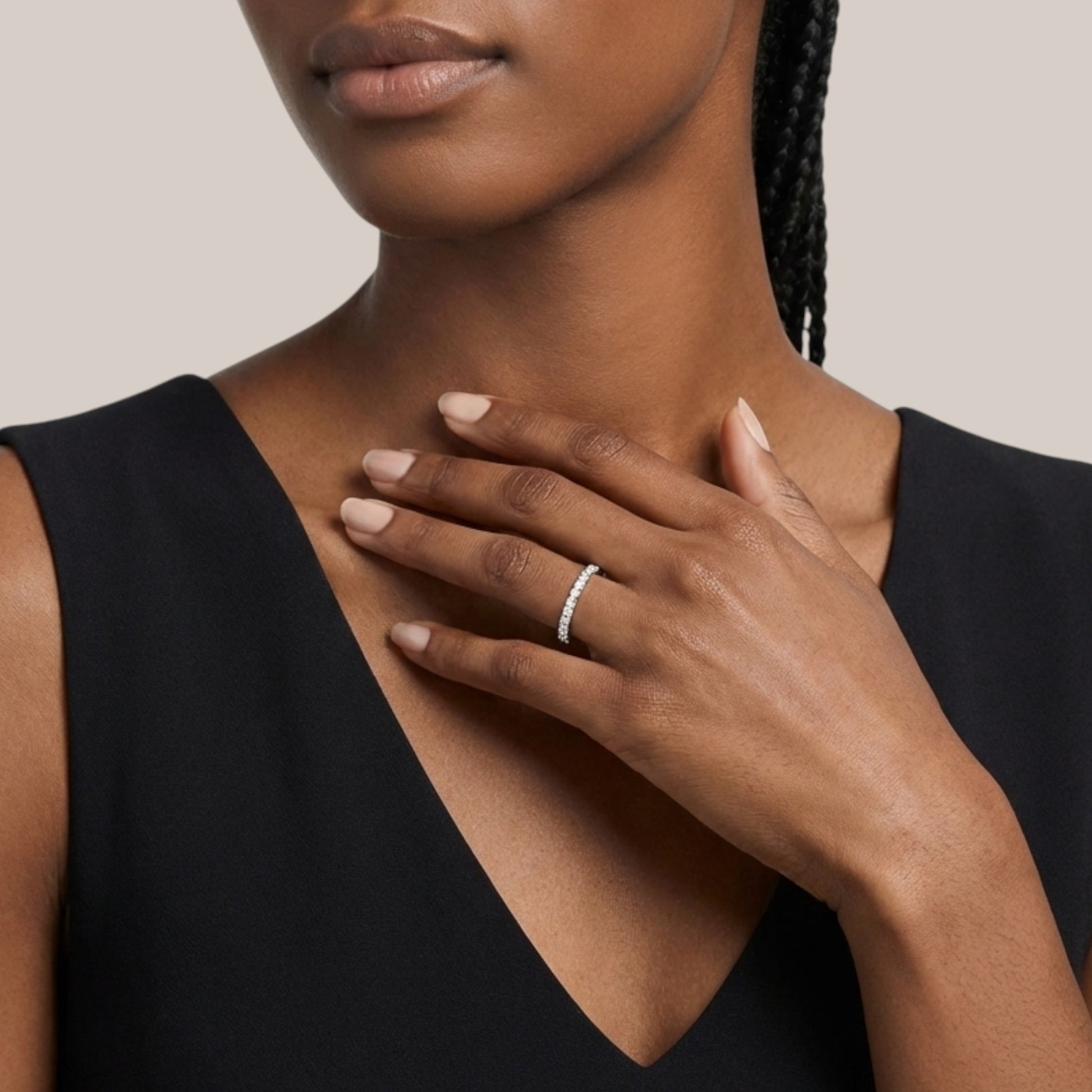 Woman wearing a black sleeveless top with a close-up of her hand and ring.