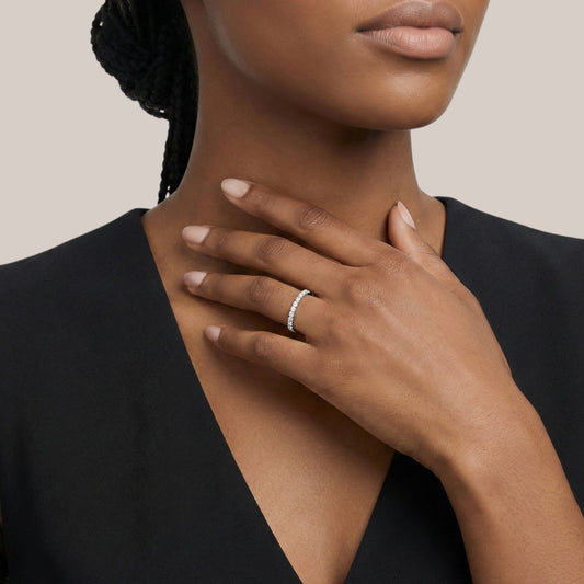 Woman wearing a silver ring on her hand with a neutral background