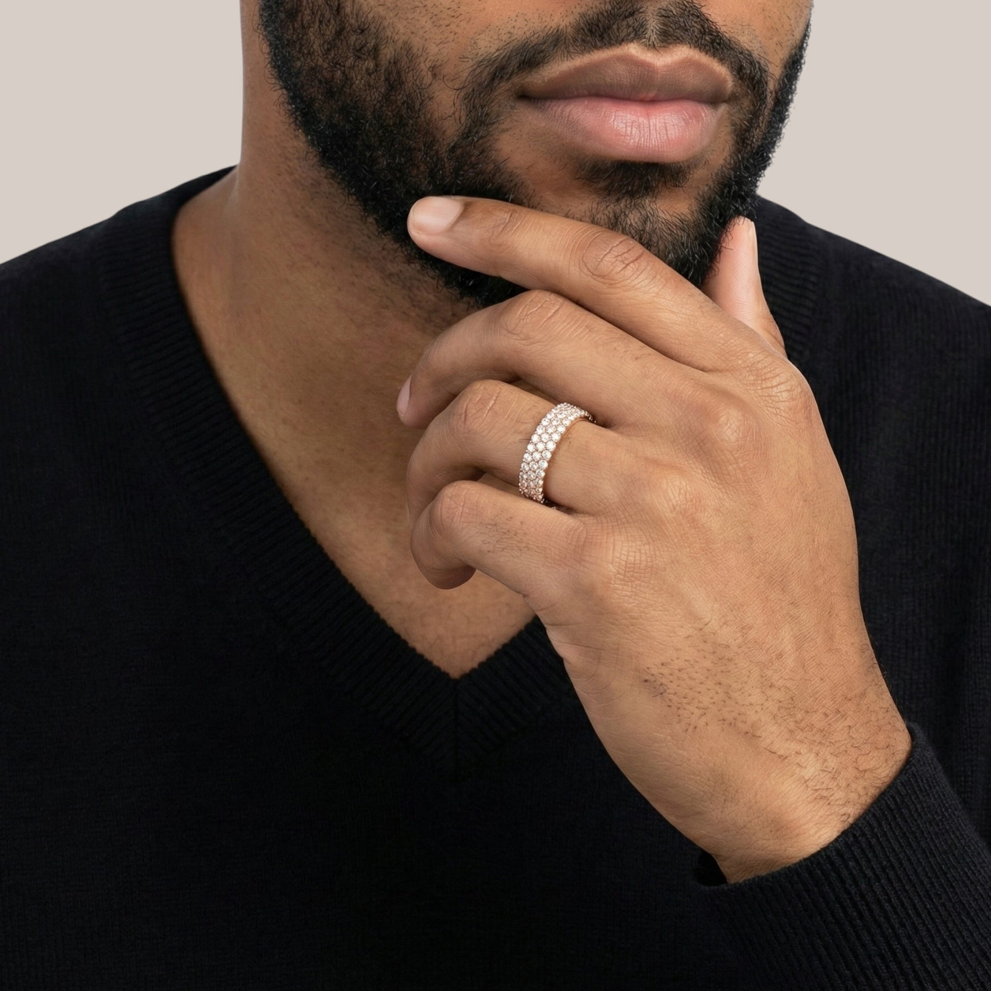 Man wearing a silver ring on his finger with a neutral background