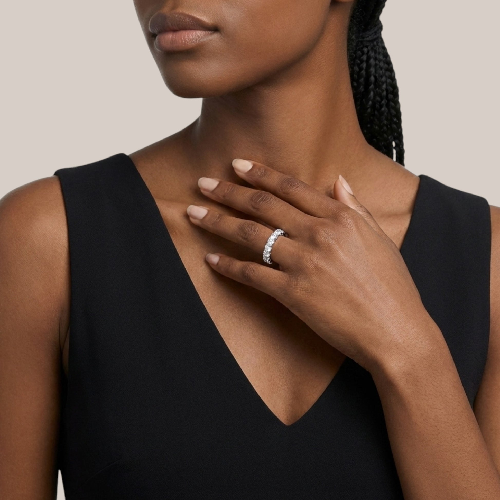 Woman wearing a black sleeveless top with a close-up of her hand and ring.