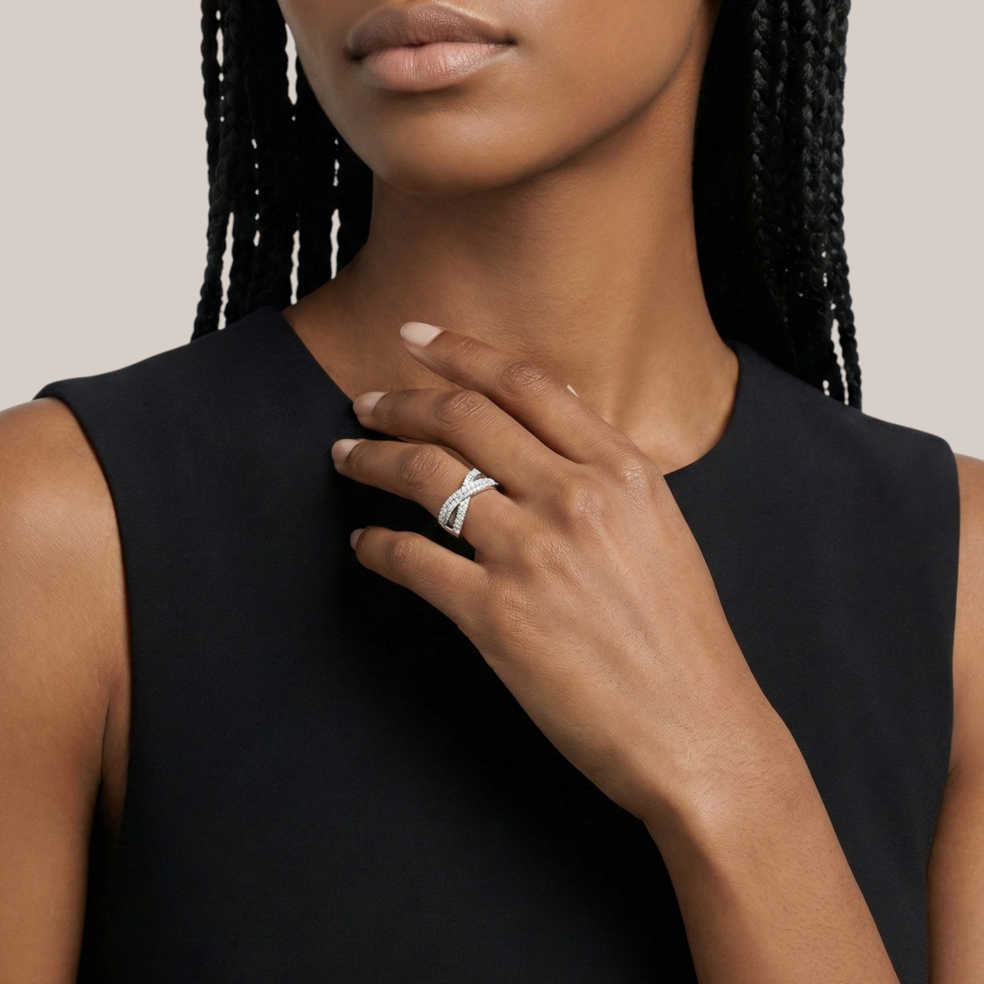 Woman wearing a black sleeveless top with a close-up of her hand and ring.