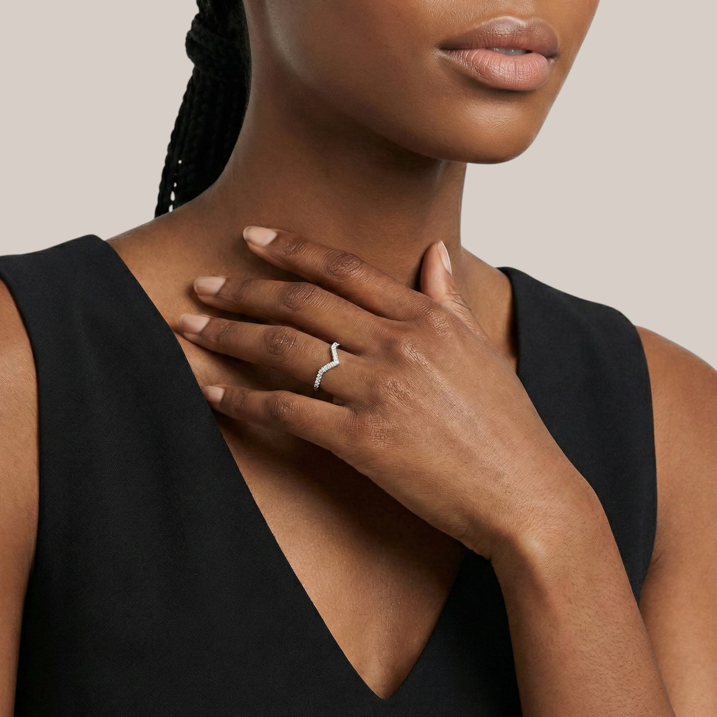 Woman wearing a black sleeveless top with a neutral background