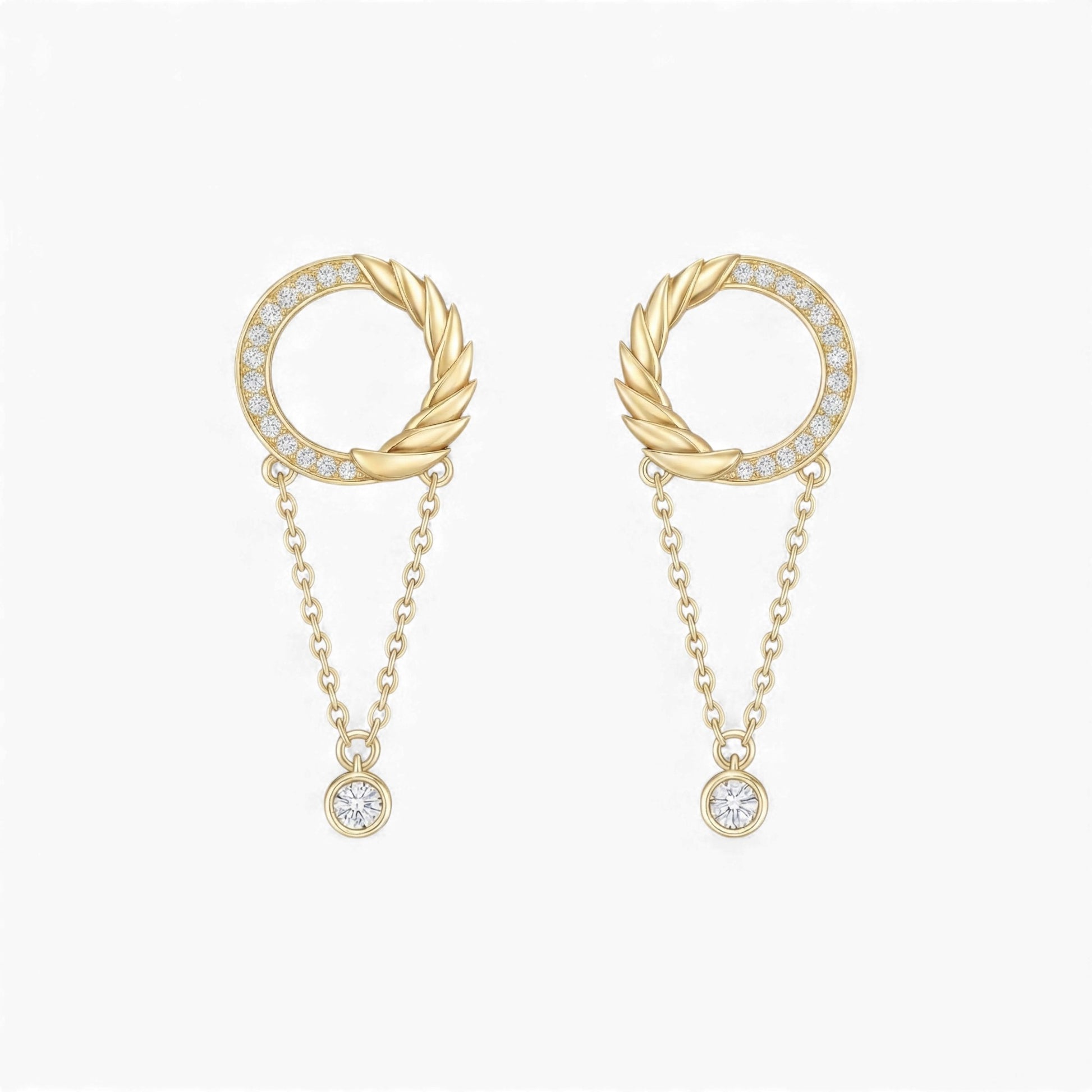 Gold earrings with circular designs and chain details on a white background