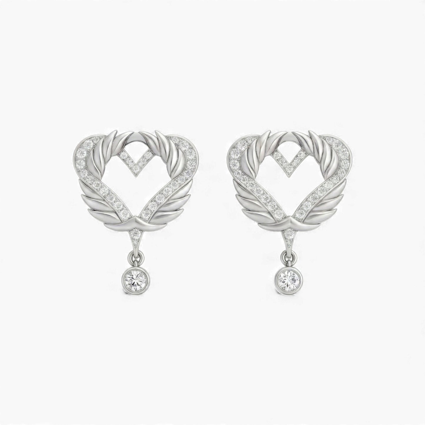 Heart-shaped earrings with feather designs and small crystals on a white background