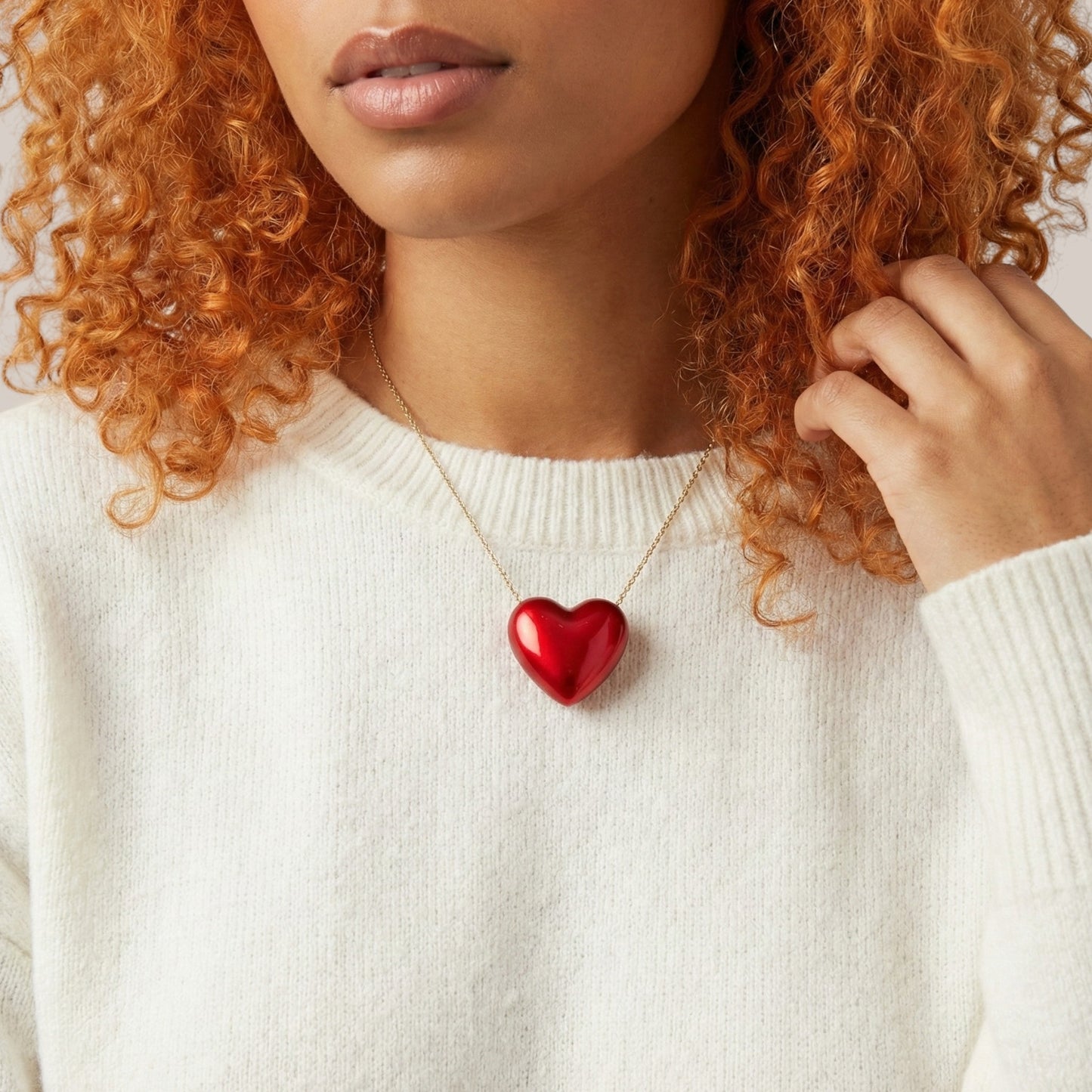 Person wearing a necklace with a red heart pendant