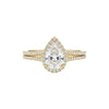 Gold ring with a pear-shaped diamond on a white background