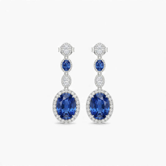 Pair of blue gemstone earrings with diamond accents on a white background