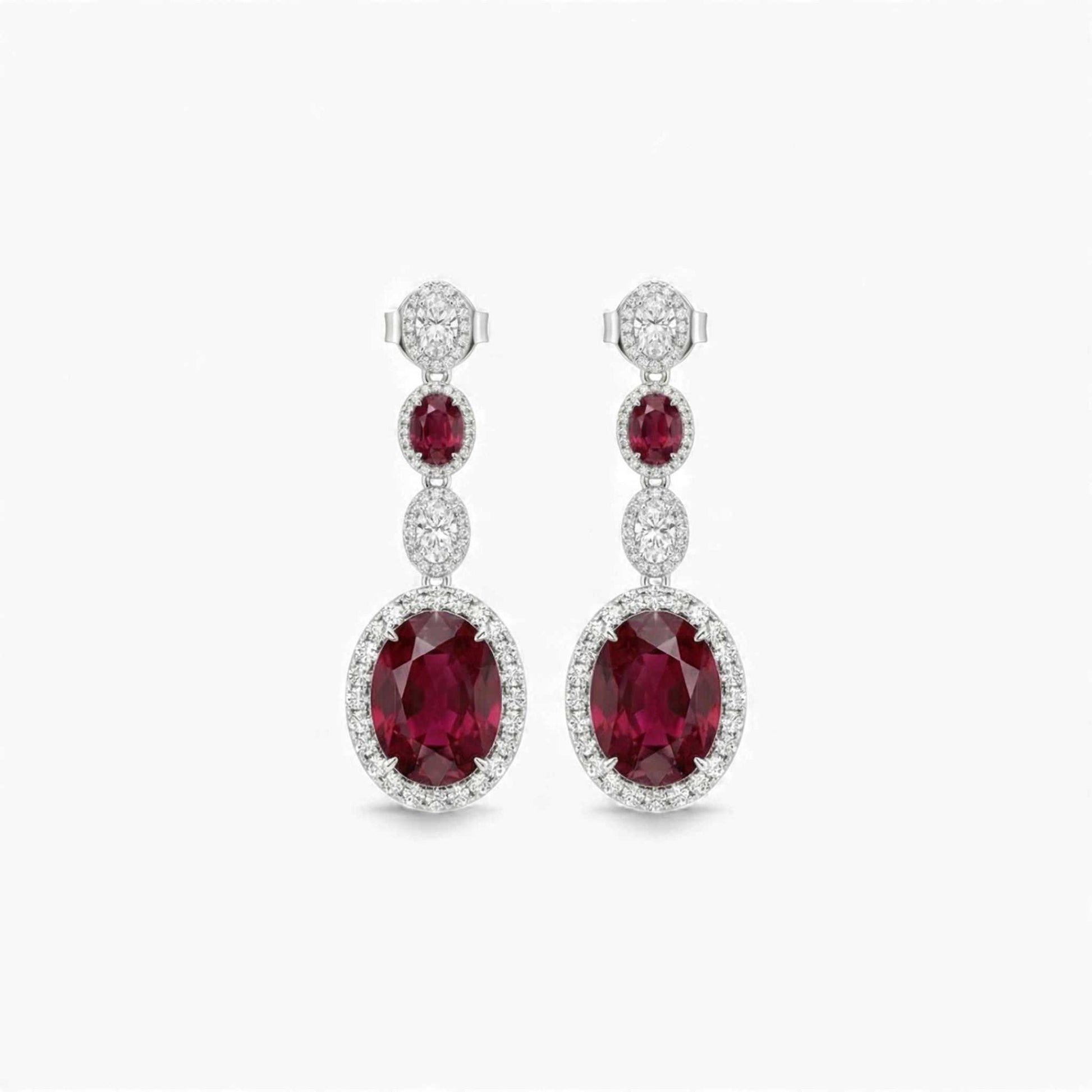 Pair of red gemstone earrings with diamond accents on a white background