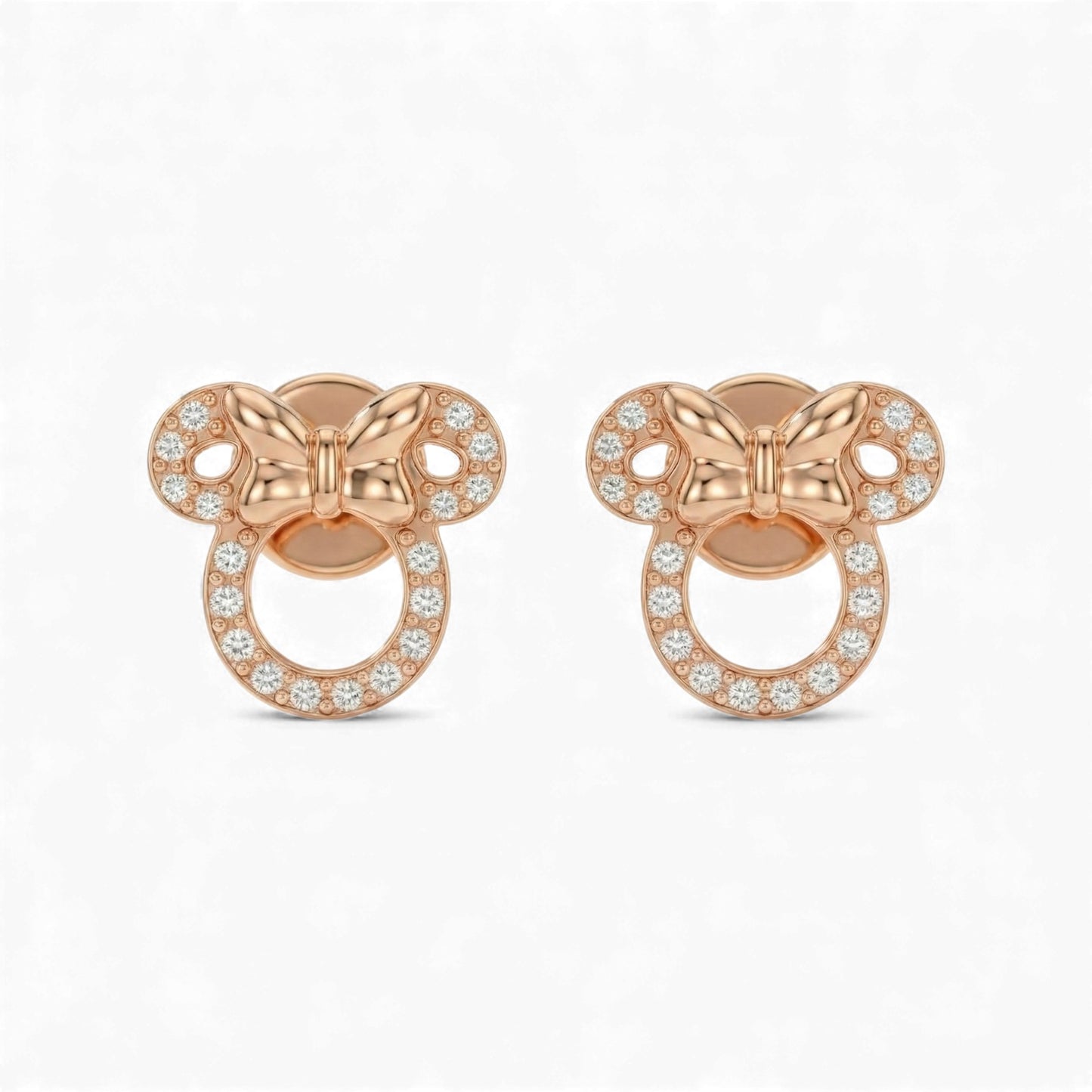 Rose gold butterfly-shaped earrings with clear gemstones on a white background