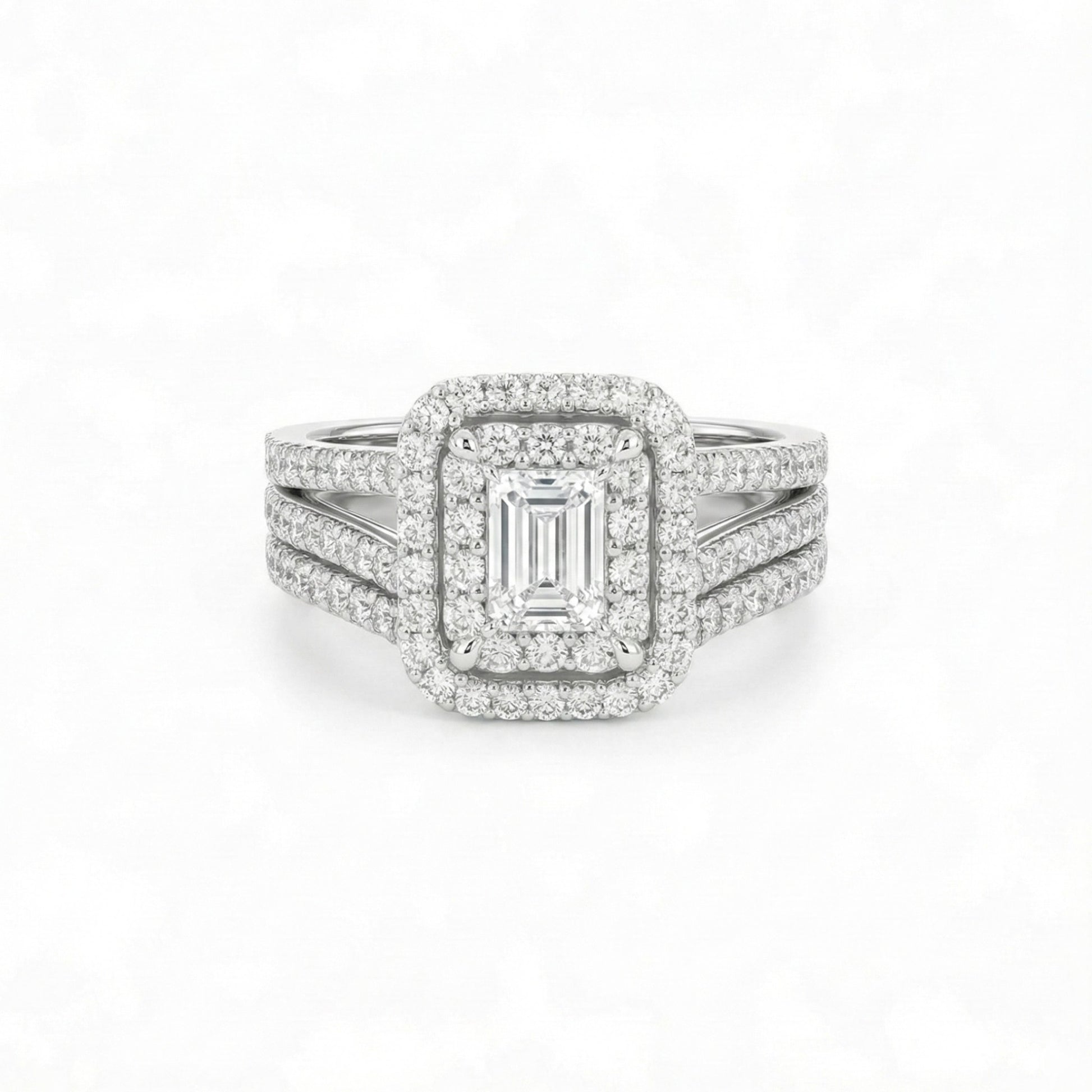 Diamond ring with emerald-cut center stone on a white background