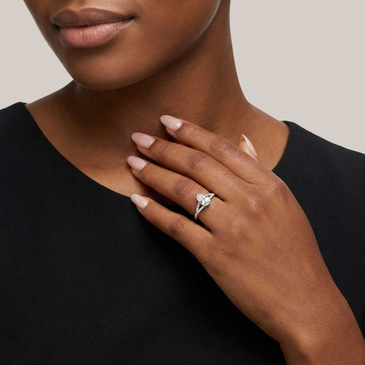 Woman wearing a diamond ring on her hand against a neutral background