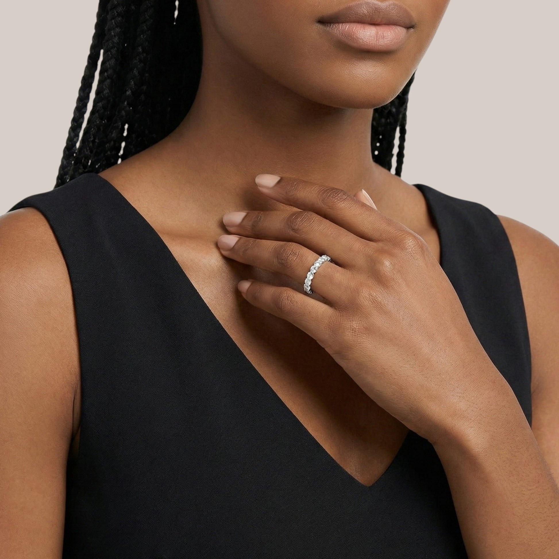 Woman wearing a black sleeveless top with a close-up of her hand and ring.