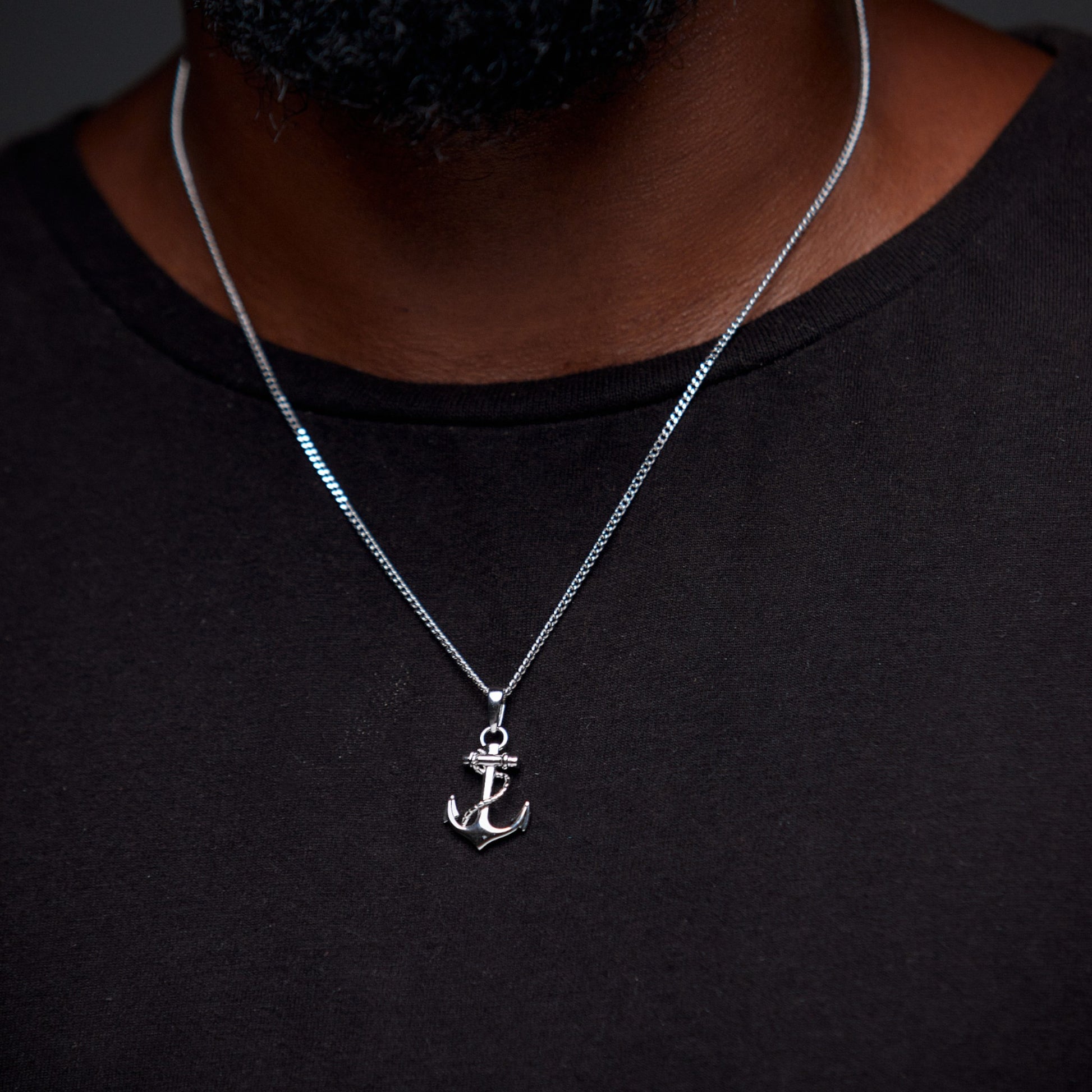 Silver anchor necklace on a black shirt