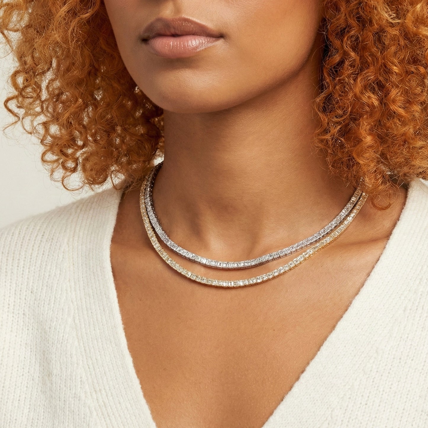 Close-up of a woman wearing a silver necklace with a neutral background