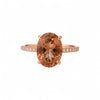 Ring with a large brown gemstone and smaller diamonds on a white background