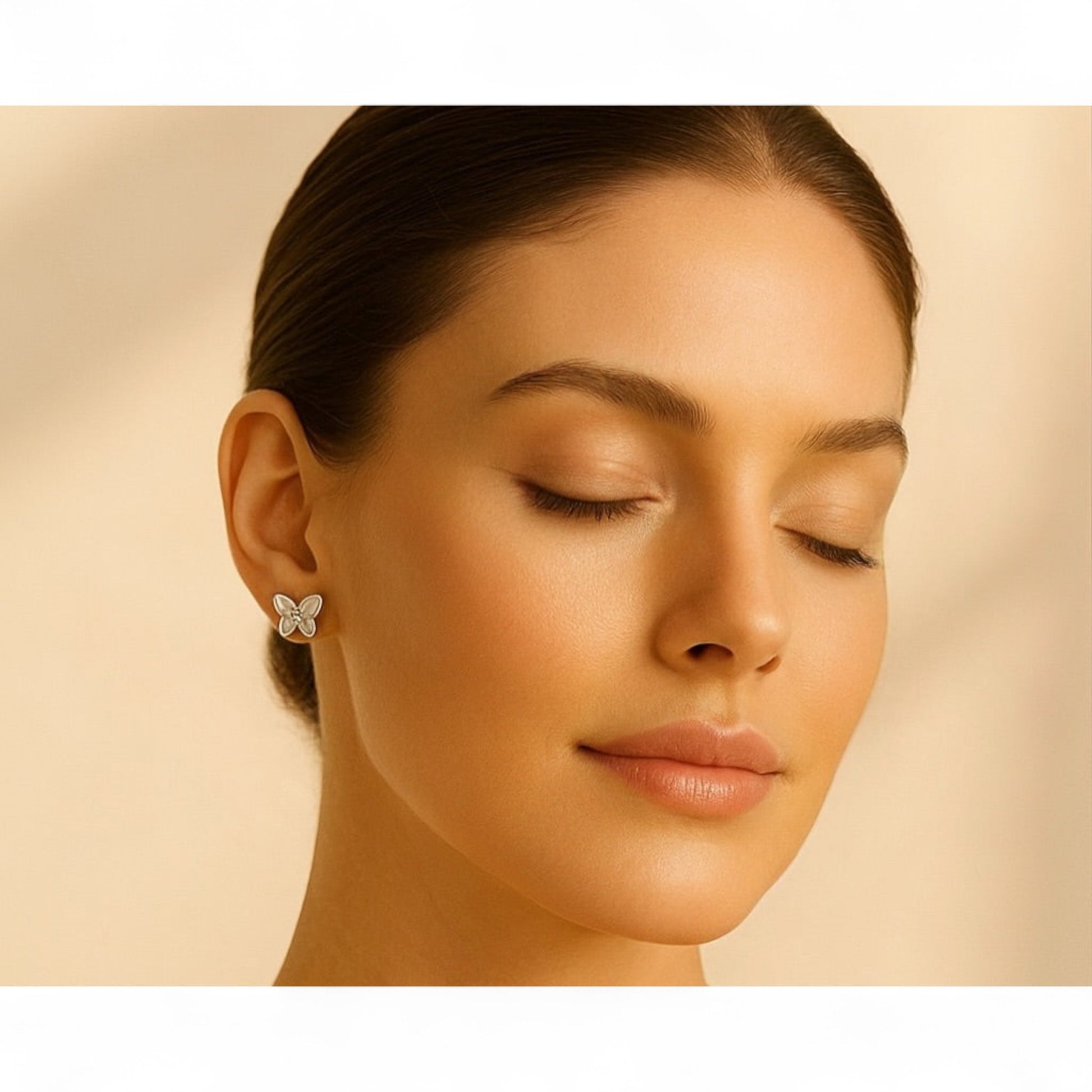 Close-up of a woman wearing a butterfly earring against a beige background