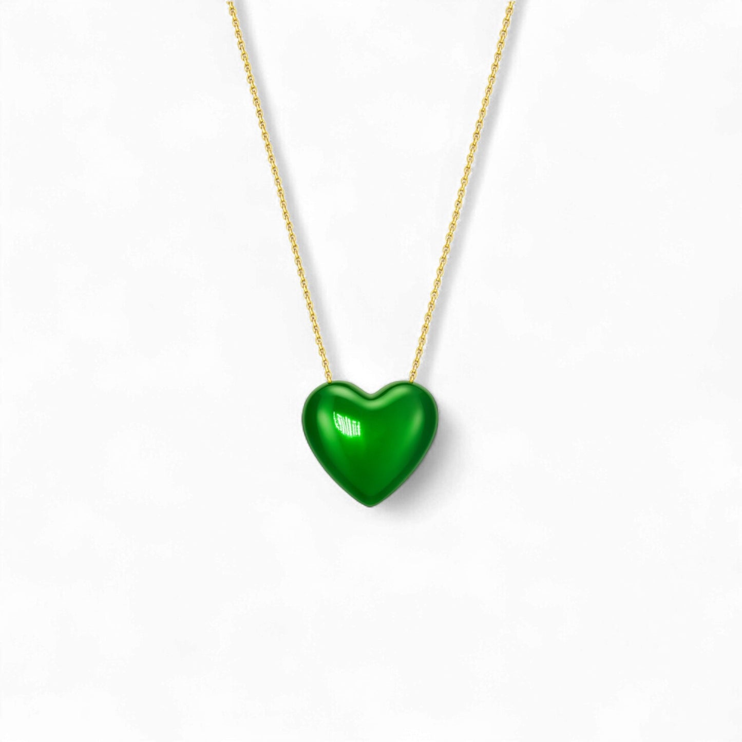Green heart-shaped pendant on a gold chain against a white background