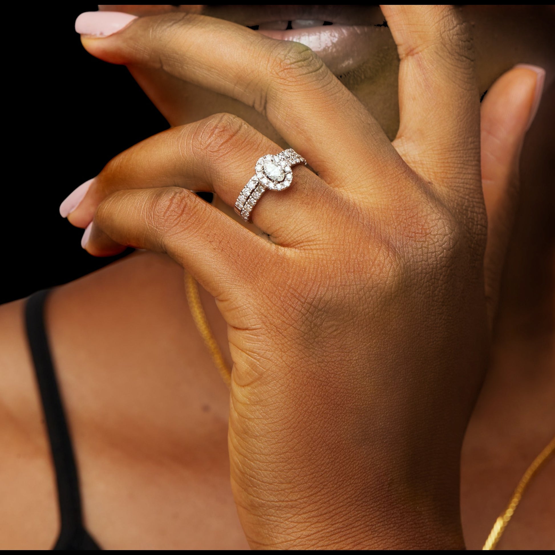 Close-up of a hand wearing a diamond ring with a blurred background