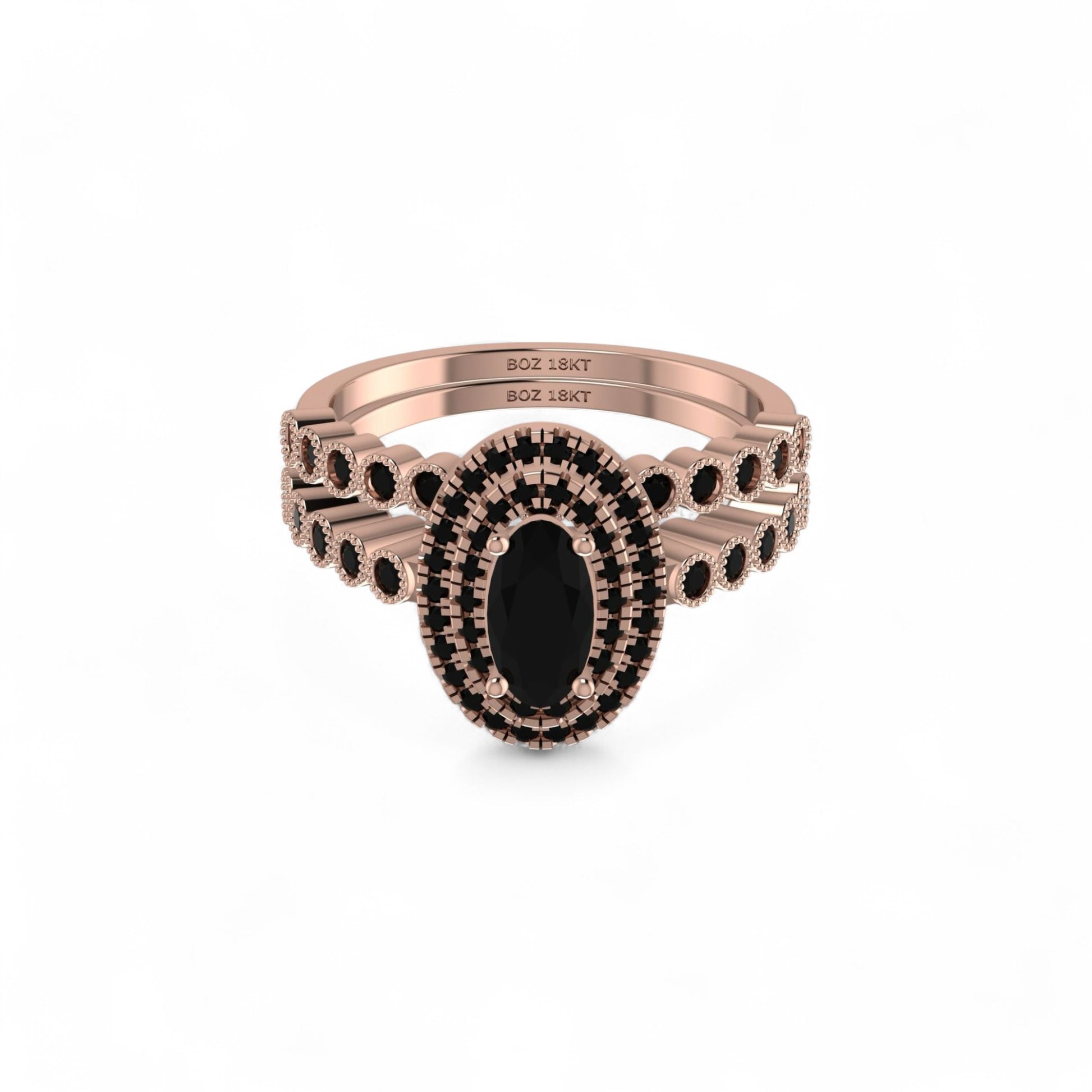 Rose gold ring with black gemstones on a white background
