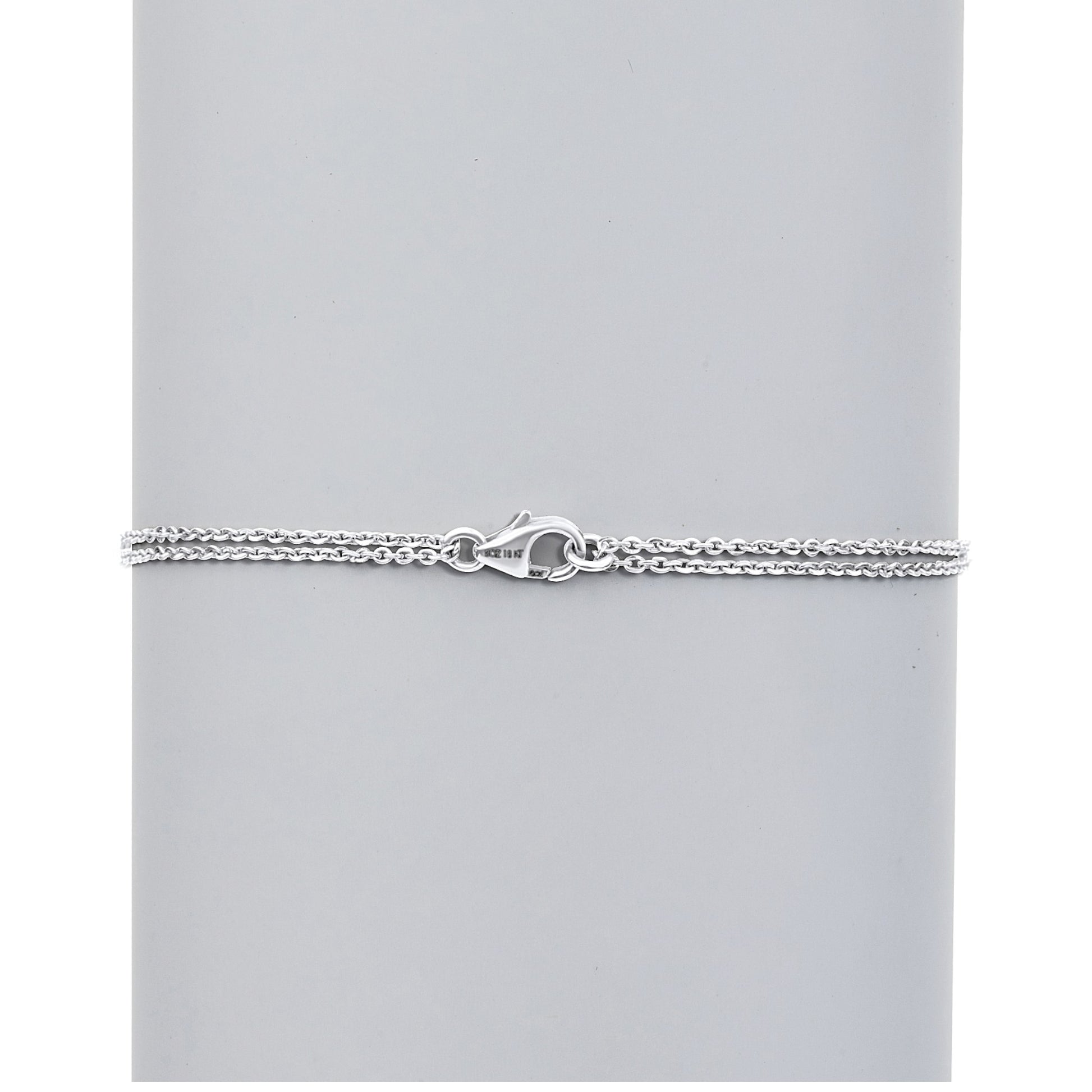 Silver chain bracelet on a light gray background