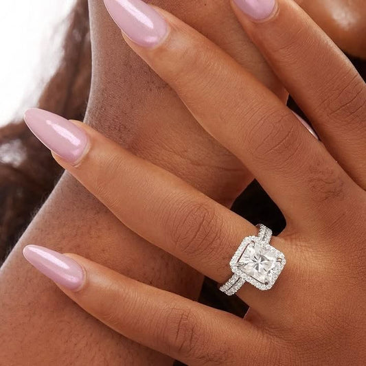 A close-up image of a person's hand wearing a Mia Princess Cut Moissanite Engagement Ring in 925 Sterling Silver, showcasing the ring on the finger.