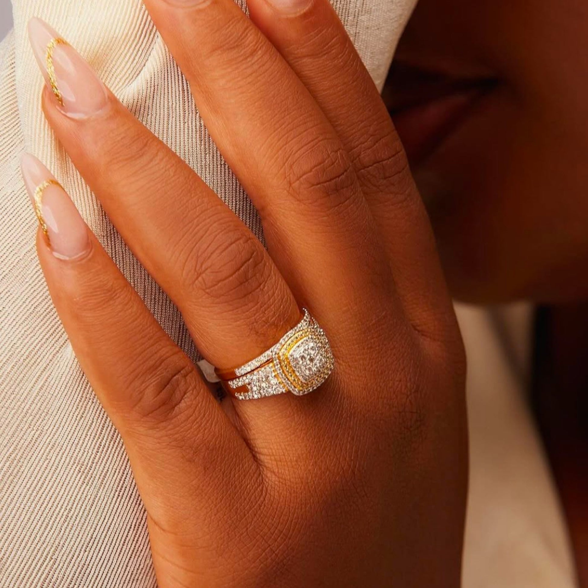 Close-up of a hand wearing a diamond ring with a blurred background
