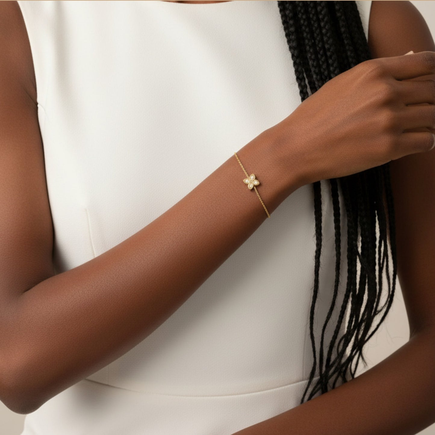 Gold bracelet on a person's wrist with a neutral background