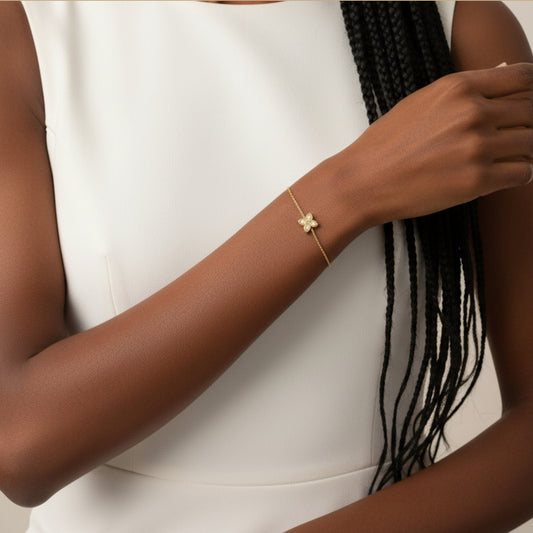 Gold bracelet on a person's wrist with a neutral background