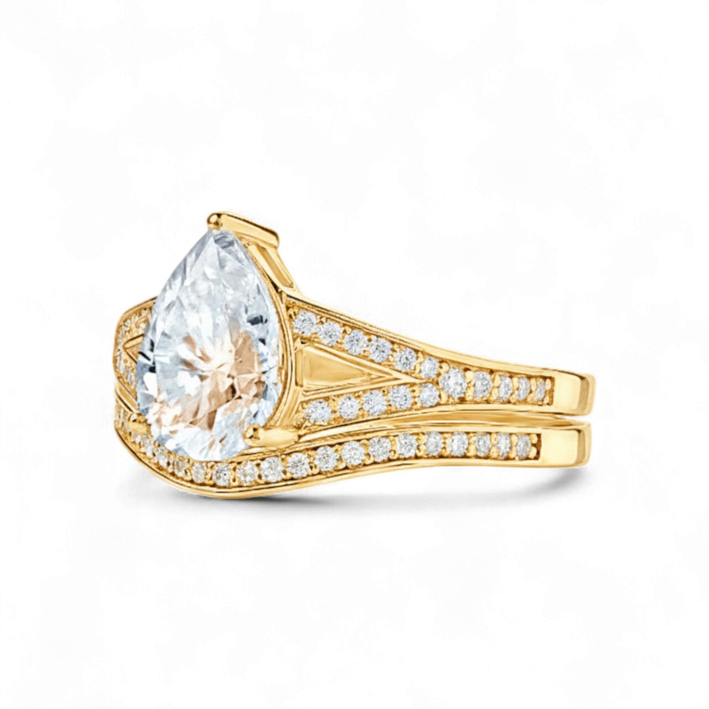 Gold ring with a large pear-shaped diamond and smaller diamonds on the band against a white background
