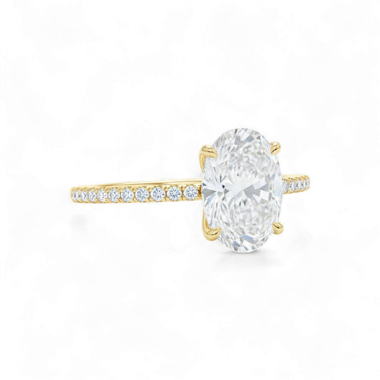 Gold ring with a large diamond and smaller diamonds on the band against a white background