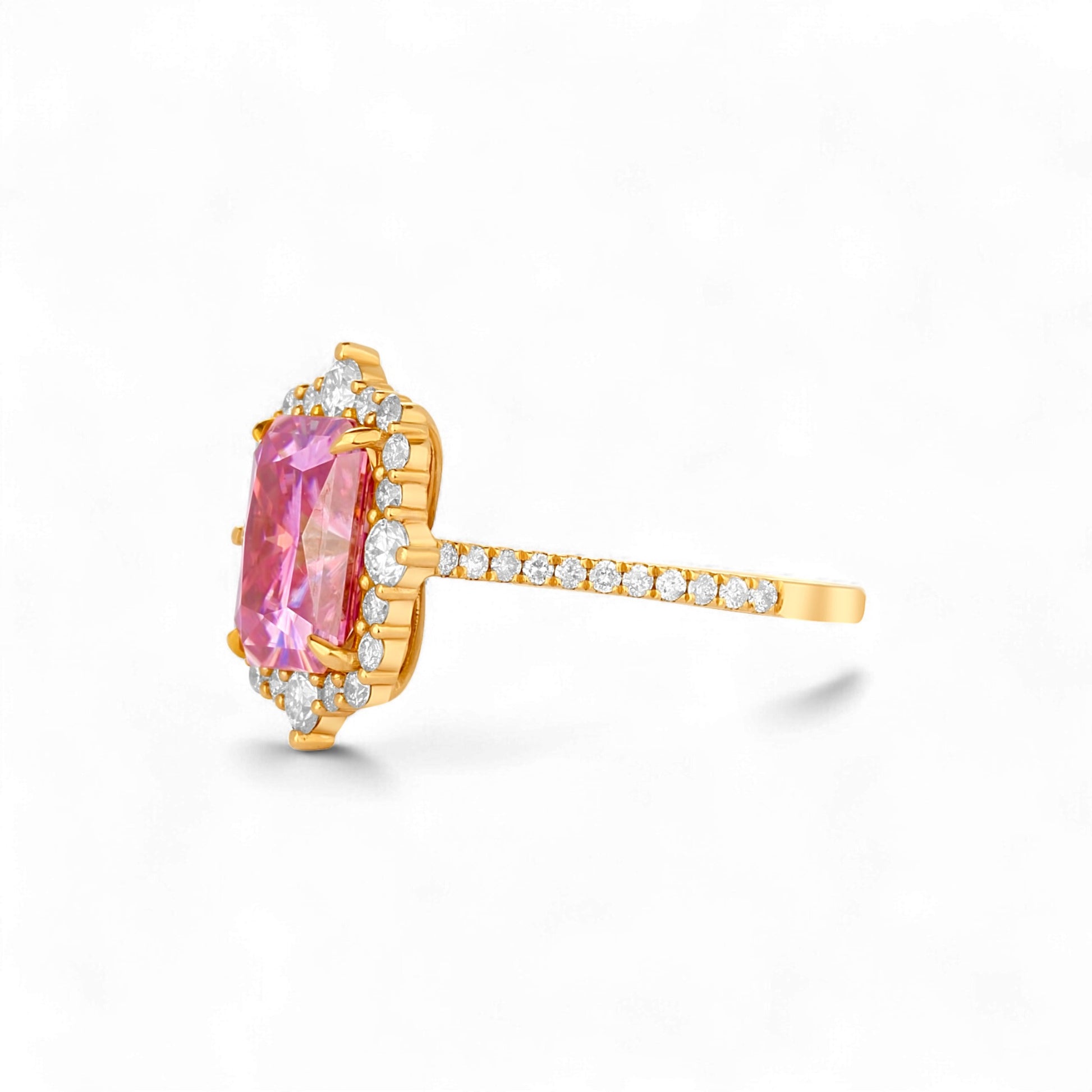 Gold ring with a pink gemstone and diamond accents on a white background
