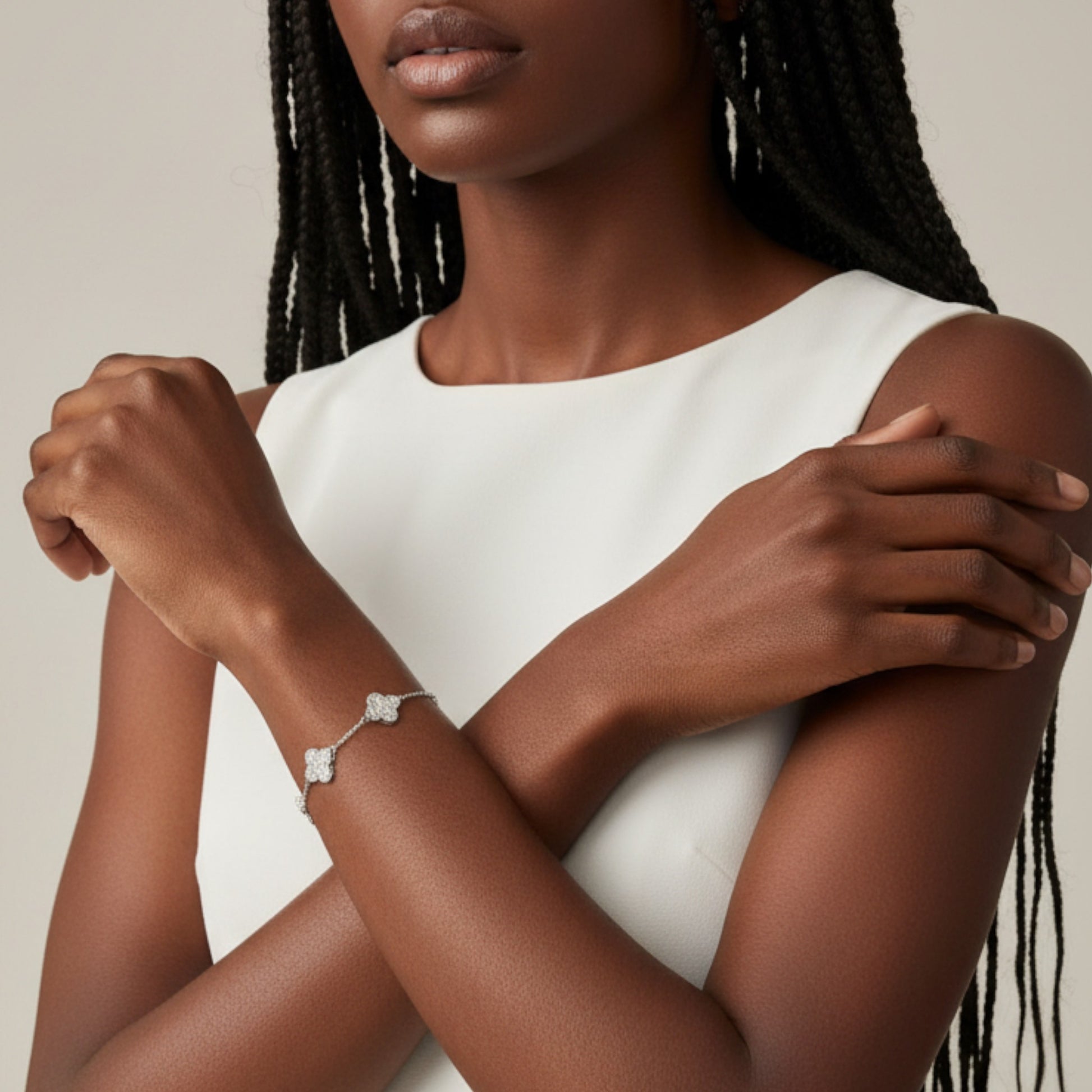 Woman wearing a white dress and silver bracelet with a beige background