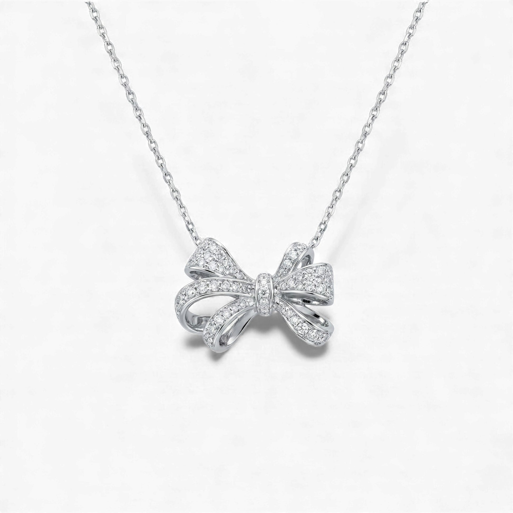 Silver bow-shaped necklace on a white background