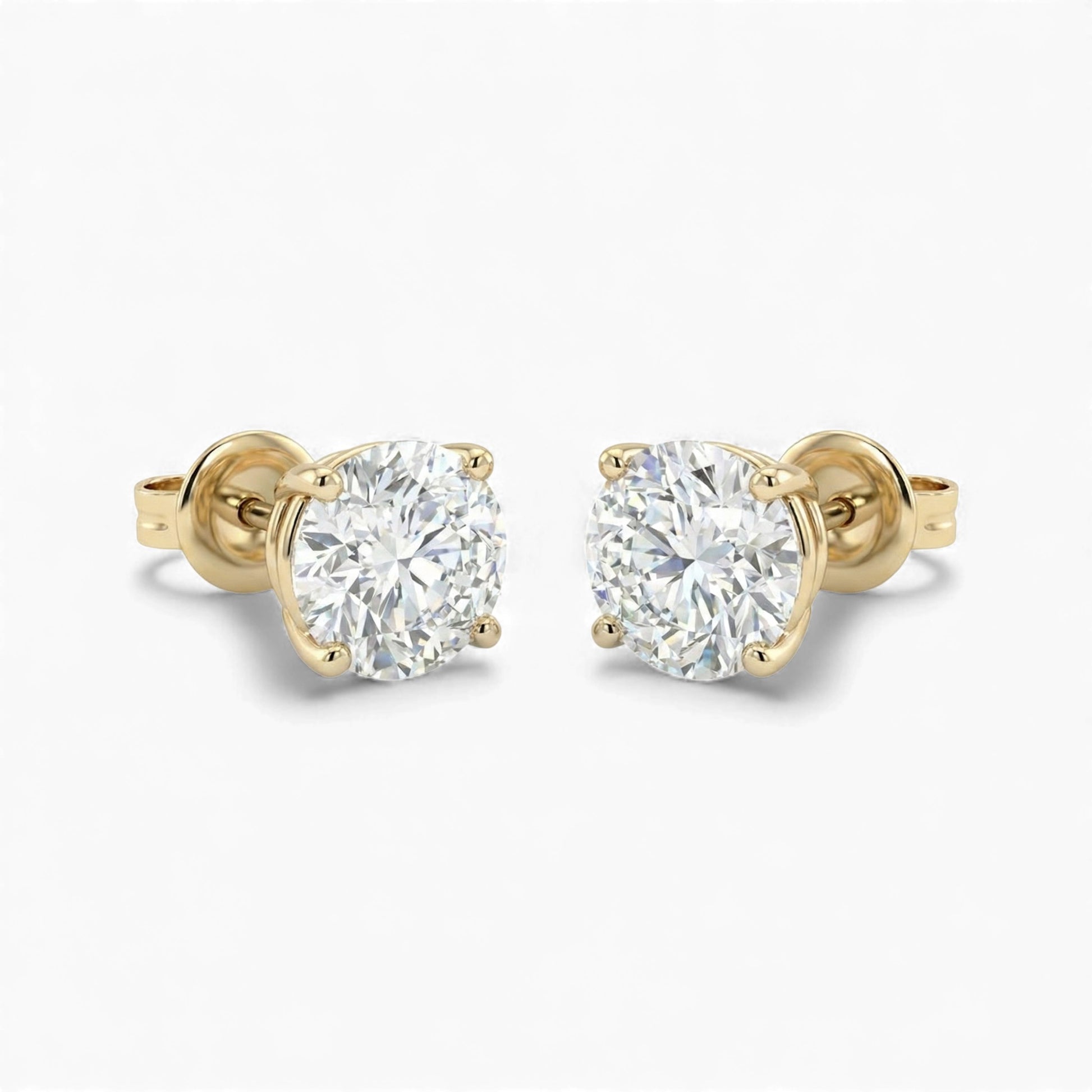 Gold stud earrings with clear gemstones on a white background