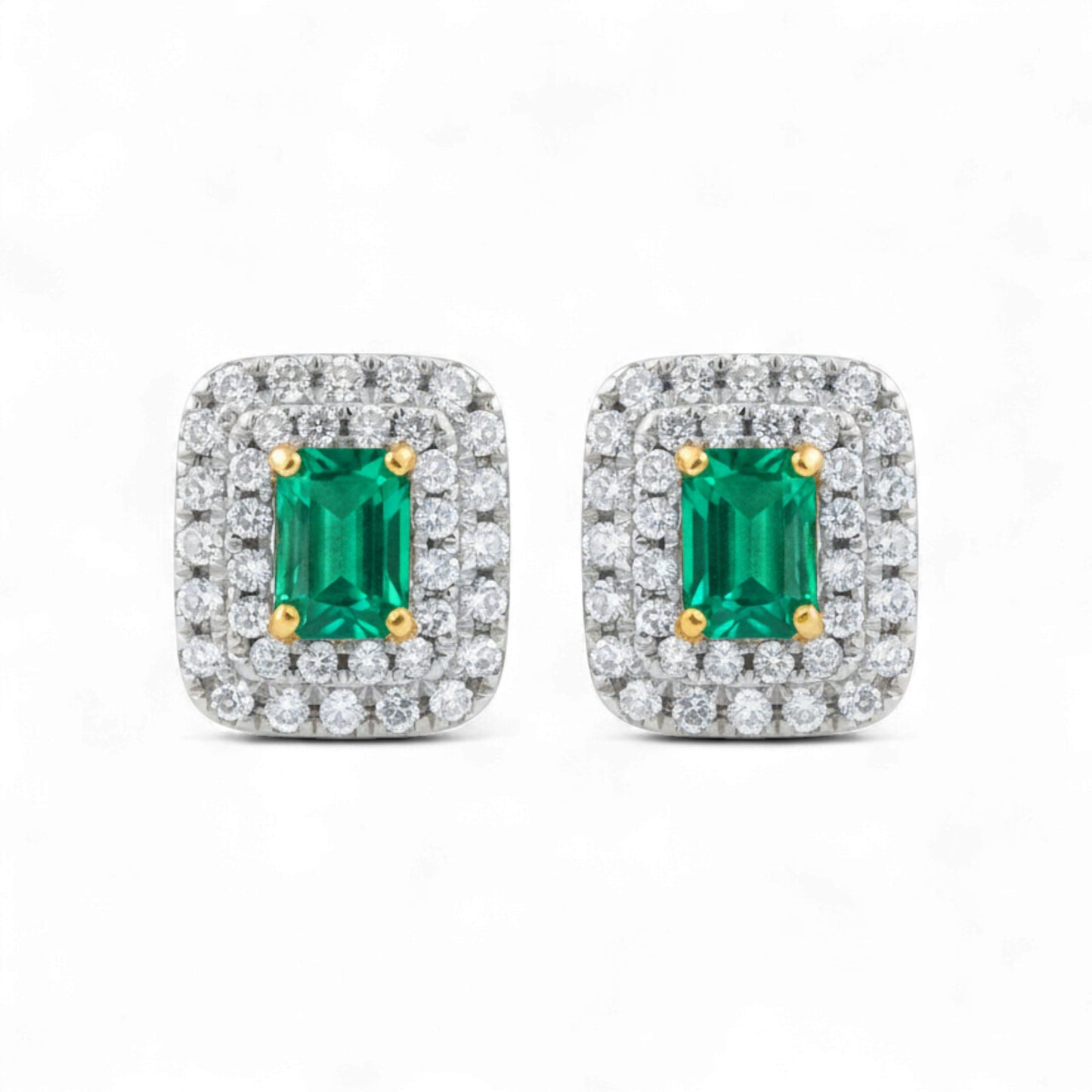 Pair of emerald cut gemstone earrings with diamond accents on a white background