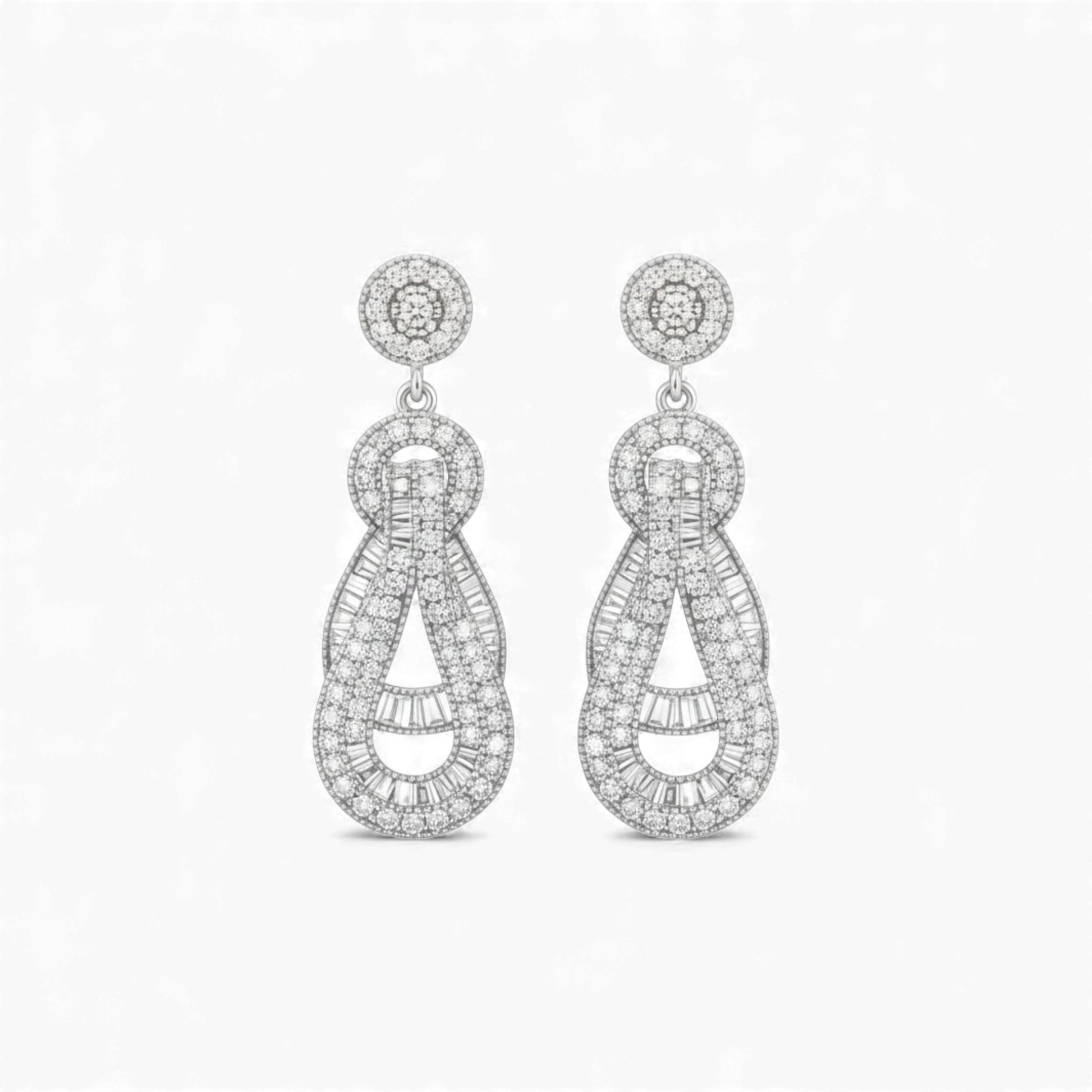 Pair of silver earrings with intricate designs on a white background