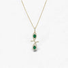Gold necklace with a pendant featuring green gemstones on a white background