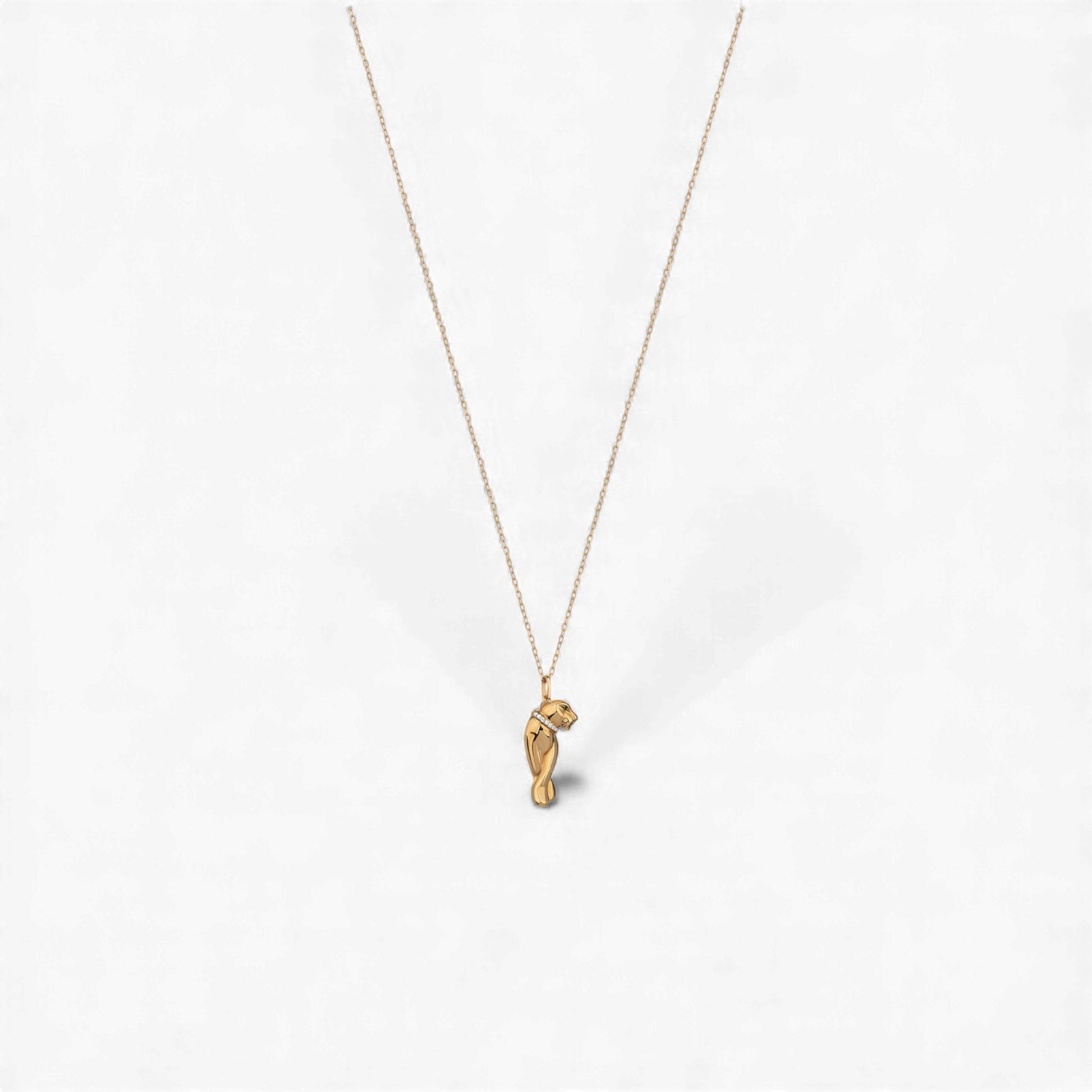 Gold necklace with a small pendant on a white background