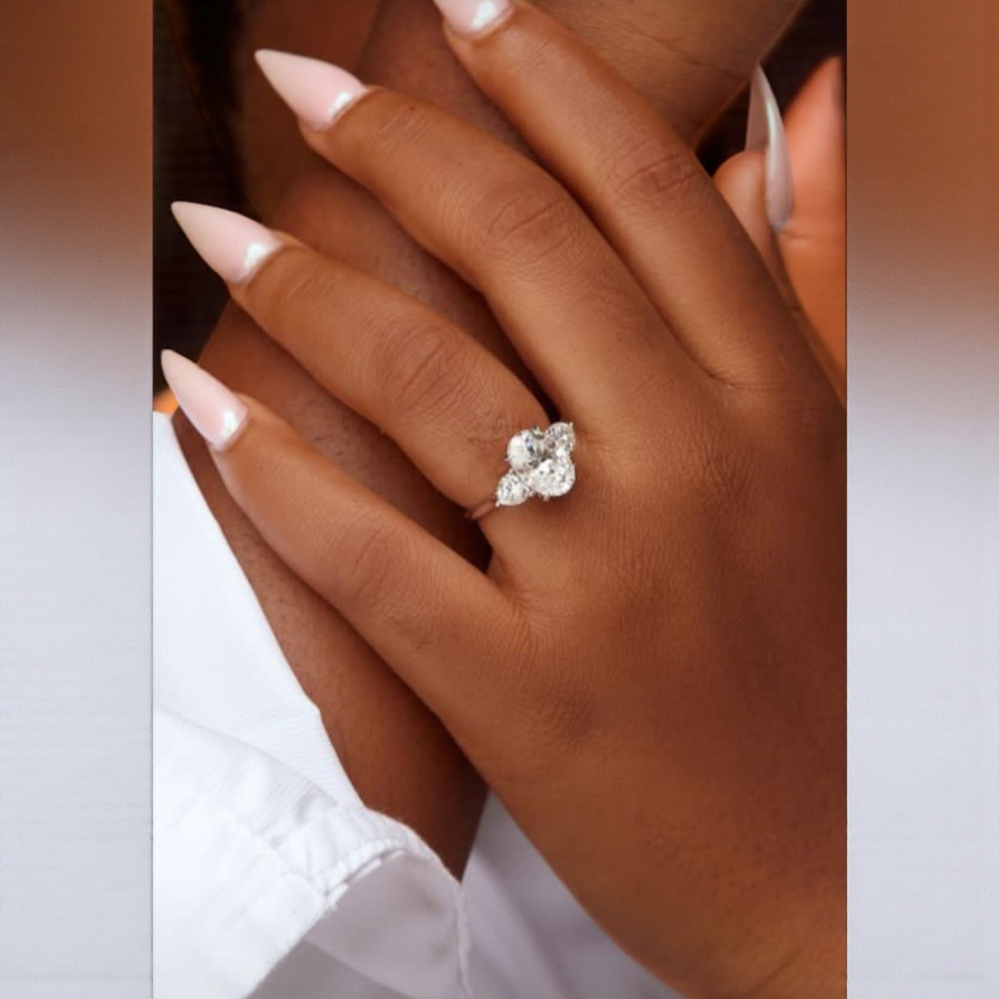 Close-up of a hand wearing a diamond ring with a blurred background